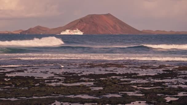Hullámok Kőpartnak Ütköznek Távolban Egy Vulkanikus Sziget Sziluettje Látható Kiváló — Stock videók