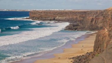 Gün batımında kayalık sahil, büyük dalgalar, Fuerteventura Adası. Yüksek kalite 4k görüntü