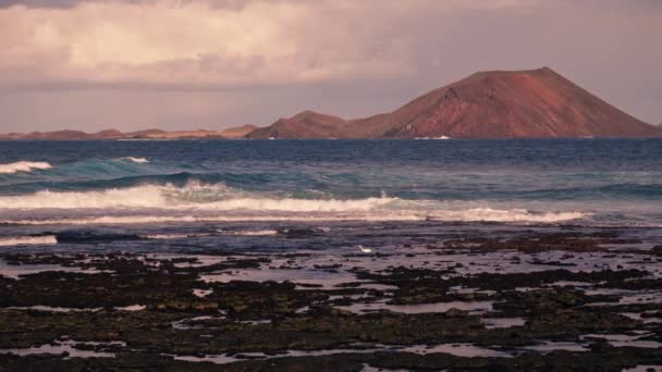 Vlny Narážejí Kamenný Břeh Dálce Vidět Silueta Sopečného Ostrova Vysoce — Stock video