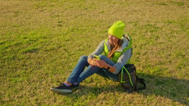 这个女孩坐在绿草和文字上 高质量的4K镜头 — 图库视频影像