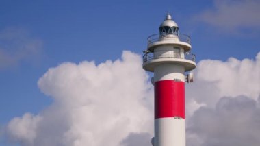 Hızlı hareket eden beyaz bulutların arka planına karşı deniz feneri. Yüksek kalite 4k görüntü