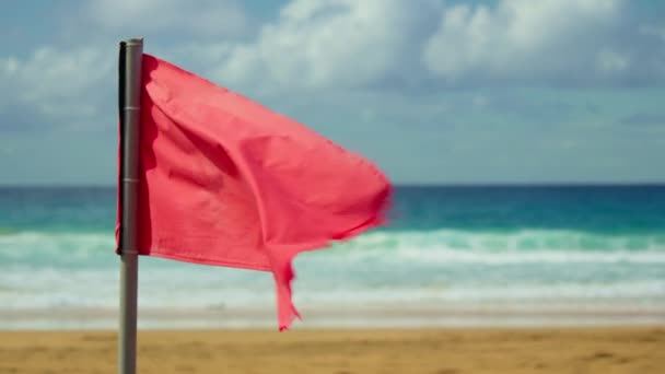 Μια Κόκκινη Σημαία Στην Παραλία Κυματίζει Στον Άνεμο Υψηλής Ποιότητας — Αρχείο Βίντεο
