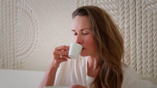 Chica Está Sentada Cama Bebiendo Una Taza Café Caliente Con — Vídeos de Stock