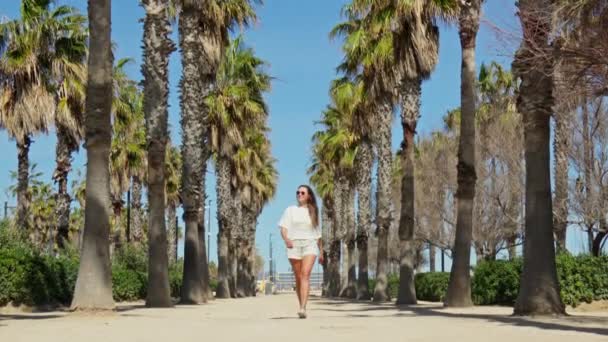 Bright Sun Girl Walks Gracefully Palm Lined Alley Embracing Warmth — Stock Video