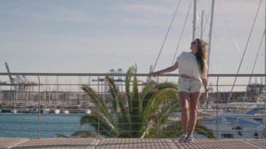 Yat kulübünün ortasında palmiye dallarının güçlü rüzgarda zarafetle sallanmasıyla büyüleyici bir manzara gözler önüne seriliyor. Yüksek kalite 4k görüntü