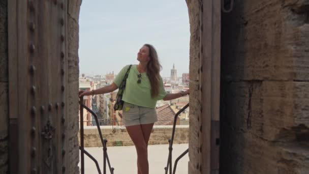 一个女孩站在一座中世纪城堡的门口 四周环绕着一座宏伟的历史建筑 捕捉着一个逝去时代的精华 — 图库视频影像