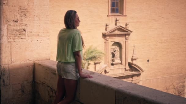 一个女孩从阳台上凝视着 被瓦伦西亚市令人惊叹的全景所吸引 她拥抱了这座城市的建筑之美和充满活力的城市景观 高质量的4K镜头 — 图库视频影像