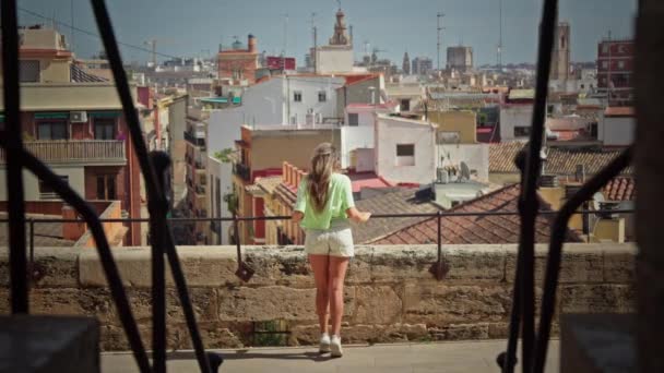 少女は要塞の壁に立って 街のパノラマビューに驚嘆します 高品質の4K映像 — ストック動画