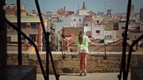 少女はバレンシアの街並みのパノラマビューに魅了されています 高品質4K映像 — ストック動画