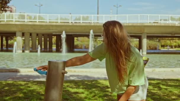 女の子公園で手を洗う 背景に噴水 高品質4K映像 — ストック動画