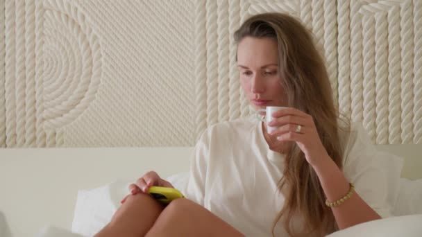 Chica Disfruta Una Mañana Perezosa Bebiendo Café Cama Mientras Escucha — Vídeos de Stock