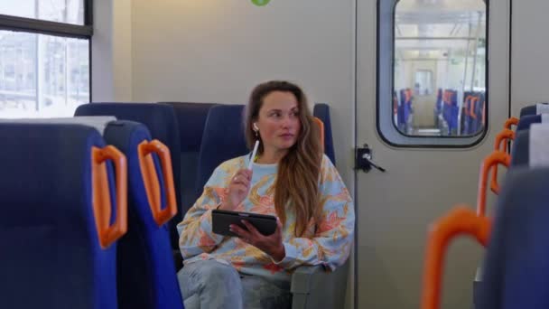 Μια Γυναίκα Κάθεται Ένα Τρένο Κοιτάζοντας Μια Ταμπλέτα — Αρχείο Βίντεο