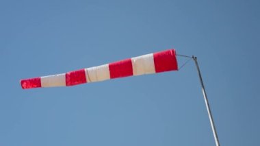Gökyüzünde dalgalanan kırmızı ve beyaz çizgili bir bayrak