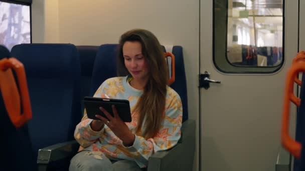 Trende Oturmuş Tablete Bakan Bir Kadın — Stok video