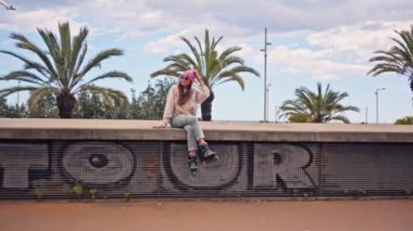 Beton duvarın üstünde kaykay süren bir adam.