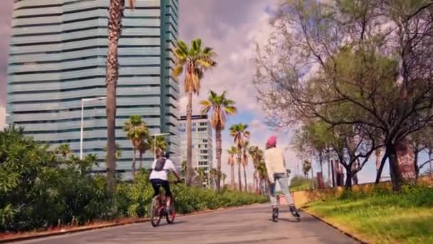 高い建物の隣の通りで自転車に乗っている男 — ストック動画