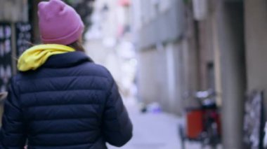 Caddede yürüyen bir kadın yüksek binaların yanında