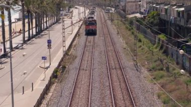 Tren raylarından sahile doğru gidiyor.