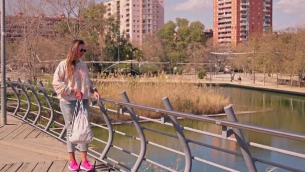 川を渡る橋を渡る女性 — ストック動画