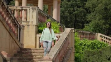 Kız parkta yürüyor, merdivenlerden iniyor. Yüksek kalite 4k görüntü