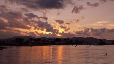 Güzel gün batımı, dağların ve denizin üzerinde pembe bulutlar. Yüksek kalite 4k görüntü