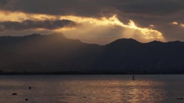 Dağların arkasında güzel bulutlar, güneşin son ışınları. Yüksek kalite 4k görüntü