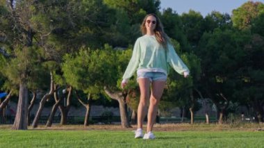Parkta çimlerin üzerinde dönen bir kız. Yüksek kalite 4k görüntü