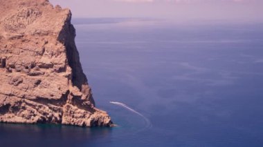 Mavi denizin üzerinde güzel, büyük bir kaya yükseliyor. Yüksek kalite 4k görüntü
