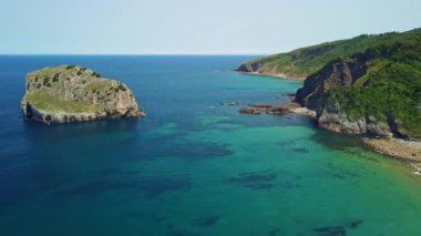 Etrafı yemyeşil bir yamaçla çevrili büyük bir su kütlesi.