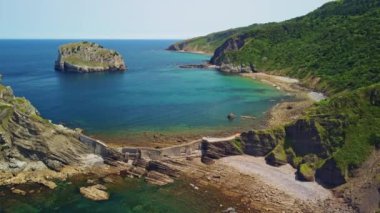 Etrafı yemyeşil bir yamaçla çevrili büyük bir su kütlesi.