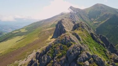 Havadan bakıldığında yemyeşil bitki örtüsüyle çevrili çarpıcı bir dağ sırası.