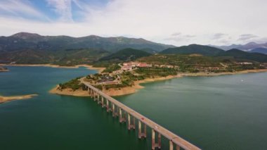 Uçsuz bucaksız bir su kütlesinin üzerinde nefes kesici bir hava perspektifinden çekilen çarpıcı bir köprü. 