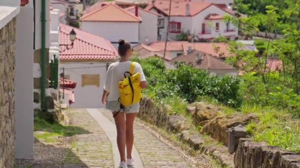 鮮やかな黄色のバックパックで街を歩く女性 — ストック動画