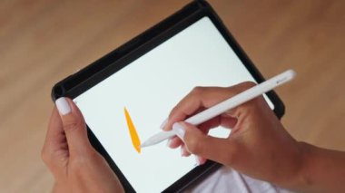 Elinde kalemle bir tablet tutan bir kişi yazmaya ya da çizmeye hazırlanıyor..