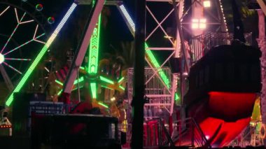 Renkli bir karnaval yolculuğu karanlık gökyüzüne karşı duruyor, parlak ve hareketli..