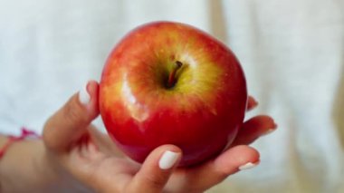 Bir kadın elinde taze bir elma tutar..