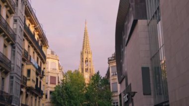 Arka planda kilise kulesi olan bir şehir caddesi..