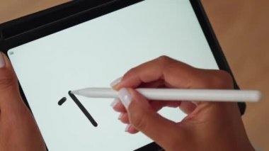 Dijital kalem kullanarak tablet üzerinde çizim yapan bir kişi.