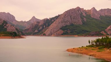 Yükselen dağlarla çevrili engin bir su kütlesi..