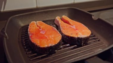 Mutfak tavasında pişen iki somon bifteği..