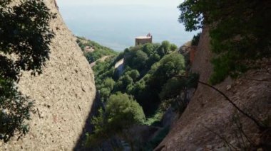Dağın tepesindeki bir ev aşağıdaki arazinin panoramik manzarasını sunar..