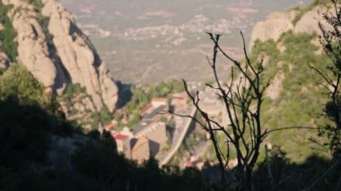 Dağların arasına yerleşmiş bir kasabanın uzak bir perspektifi manzarayı ve mimariyi sergiliyor..