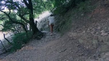 Huzurlu, doğal bir ortamda huzurlu bir nehre paralel giden bir yolda yürüyen bir insan..