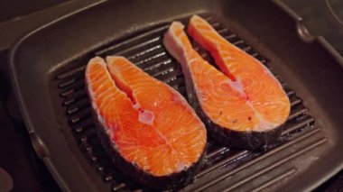 Üç parça somon fileto açık havada ızgarada cızırdıyor..