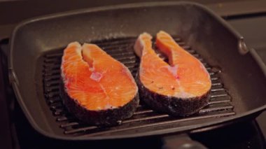 Izgarada dinlenen iki parlak portakal dilimi ızgara ya da pişirmeye hazır..