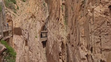 Dar bir kanyon, açık bir gökyüzünün altındaki kayalık kayalıkları ortaya çıkarır. Ziyaretçiler ahşap kaldırımlar boyunca bölgeyi keşfedip büyüleyici doğal güzellikleri içine çekiyorlar..