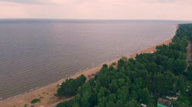 Yumuşak dalgalar, bereketli ağaçların oluşturduğu kumlu bir kıyıya çarpar sakin bir günbatımı saatinde sakin bir göl kenarı kaçışını..