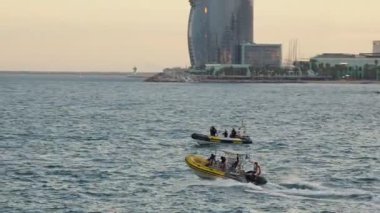 Suyun içinden geçen iki sürat teknesi çarpıcı bir günbatımında canlı bir şehir manzarasına karşı heyecan ve macera sergiliyor..