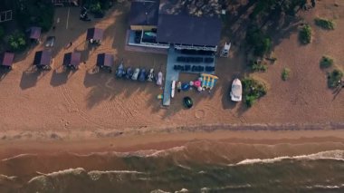 Güneşle ıslanmış bir plajda dinlenme, dinlenme ve ahşap barınakların gölgeleme, keşif ve eğlence sunduğu yerde rahatlama başlar..