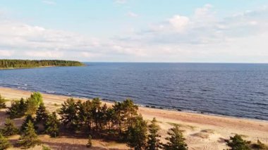 Altın kumlar yemyeşil sularla buluşur. Yumuşak dalgalar, sakin bir yaz öğleden sonrasında açık mavi gökyüzünün altında süzülür..
